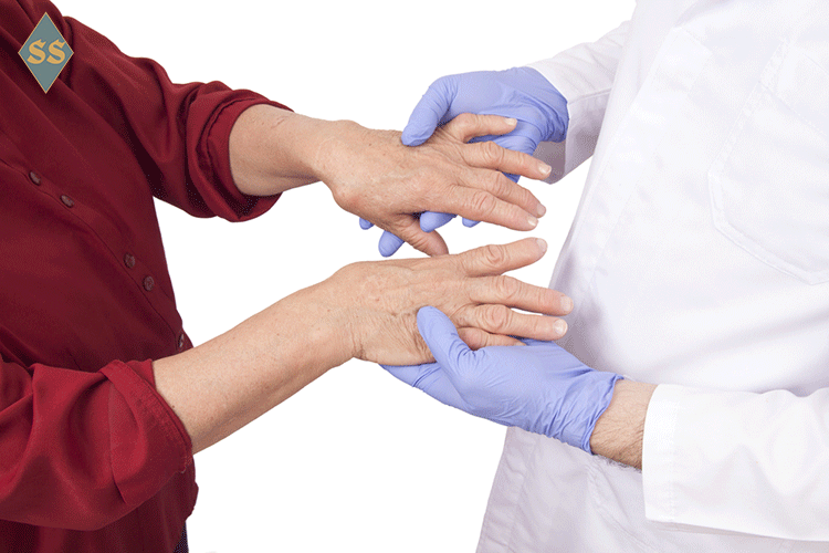 Женщина показывает суставы пальцев рук доктору